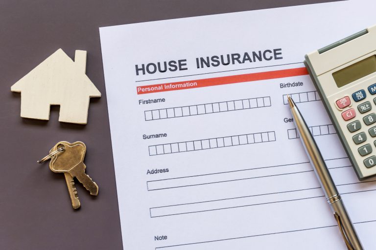 House insurance policy application form with pen, calculator, keys, and miniature house model